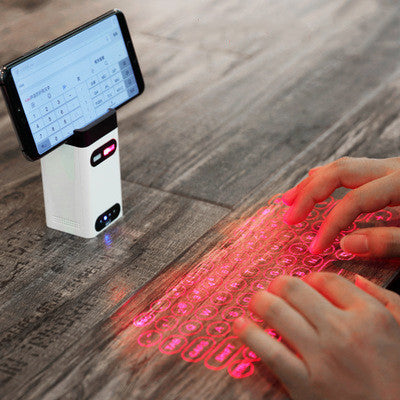 Virtual Laser Keyboard Bluetooth Wireless Projector projecting a keyboard onto a surface with a smartphone.